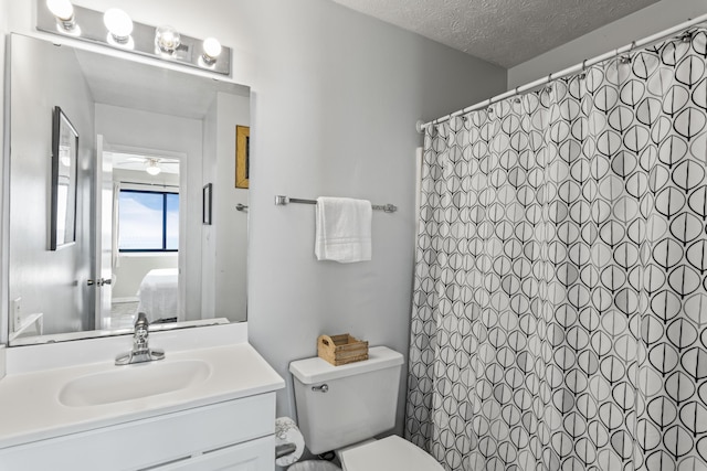 3692 E County Highway 30a Unit 9, Santa Rosa Beach, FL 32459 - ensuite bathroom with vanity, ceiling fan, toilet, a textured ceiling, and a shower with shower curtain
