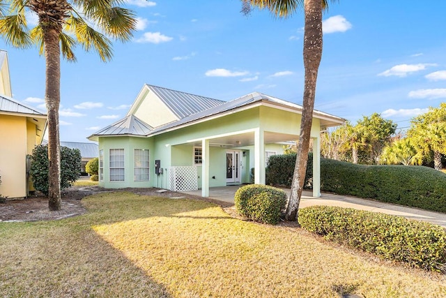 114 Mainsail Dr Unit C28, Miramar Beach, FL 32550 - view of front of house with stucco siding, a front lawn, french doors, metal roof, and an attached carport