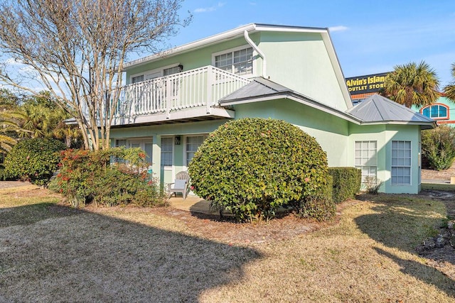 114 Mainsail Dr Unit C28, Miramar Beach, FL 32550 - rear view of house with stucco siding, a balcony, and a lawn
