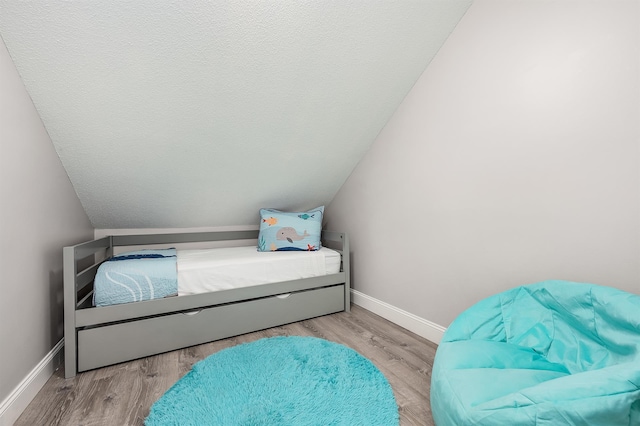 114 Mainsail Dr Unit C28, Miramar Beach, FL 32550 - bedroom with baseboards, wood finished floors, and lofted ceiling