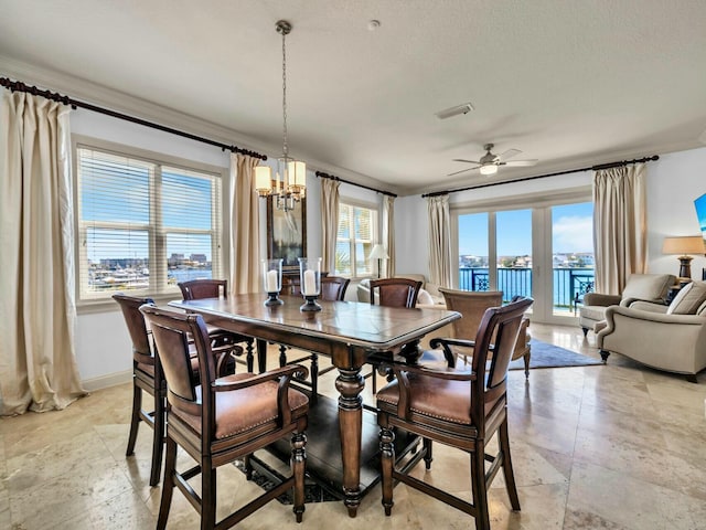 602 Harbor Blvd Unit 201, Destin, FL 32541 - dining area featuring ceiling fan, a chandelier, baseboards, light stone finish floors, and ornamental molding