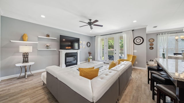 880 Lowery Dr, Fort Walton Beach, FL 32547 - living room with crown molding, a glass covered fireplace, a ceiling fan, light wood-style floors, and baseboards