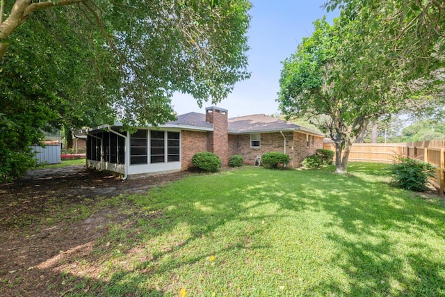 538 22nd St, Niceville, FL 32578 - rear view of property featuring a sunroom, brick siding, and a chimney