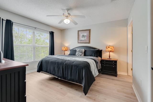 4270 Calinda Ln Unit 343, Niceville, FL 32578 - bedroom featuring a textured ceiling, light wood-style flooring, baseboards, and ceiling fan