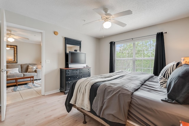 4270 Calinda Ln Unit 343, Niceville, FL 32578 - bedroom featuring light wood-style flooring, ceiling fan, a textured ceiling, and baseboards