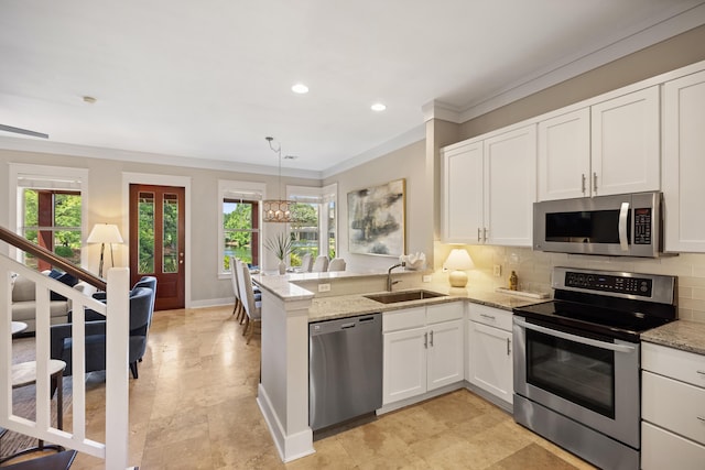 8585 Magnolia Bay Ln, Miramar Beach, FL 32550 - kitchen with appliances with stainless steel finishes, a sink, crown molding, plenty of natural light, and white cabinets