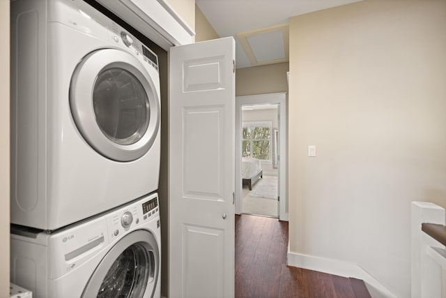 8585 Magnolia Bay Ln, Miramar Beach, FL 32550 - laundry area featuring estacked washer and dryer, dark wood-style floors, and baseboards