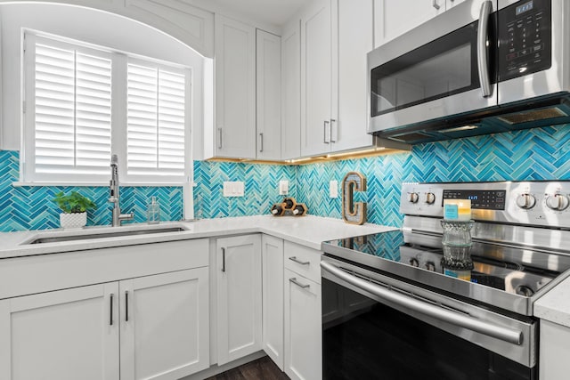 130 Durango Rd Unit 104, Destin, FL 32541 - kitchen featuring stainless steel appliances, a sink, decorative backsplash, light countertops, and white cabinetry