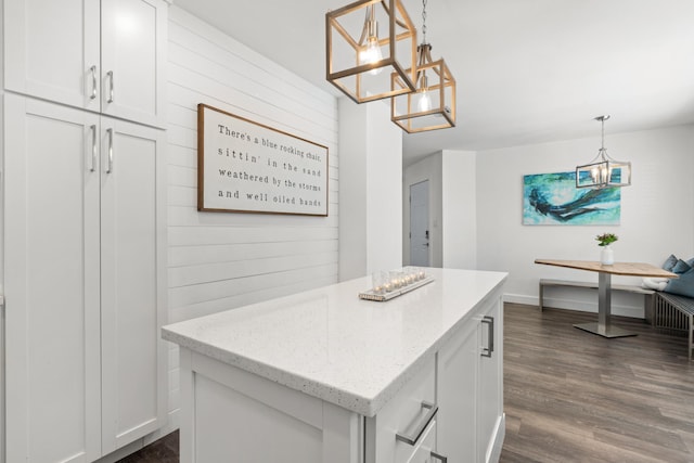 130 Durango Rd Unit 104, Destin, FL 32541 - kitchen featuring a chandelier, white cabinets, a kitchen island, light stone countertops, and wooden walls