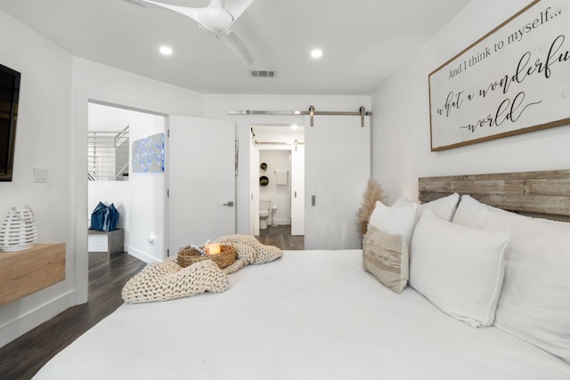 130 Durango Rd Unit 104, Destin, FL 32541 - bedroom featuring a barn door, a walk in closet, dark wood-style flooring, recessed lighting, and connected bathroom