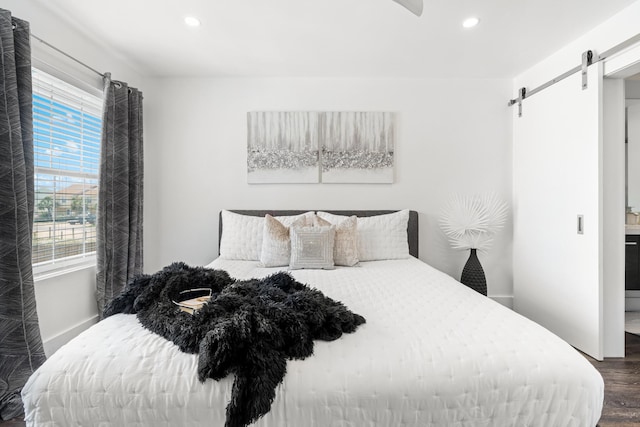 130 Durango Rd Unit 104, Destin, FL 32541 - bedroom with a barn door, dark wood-style floors, recessed lighting, and baseboards