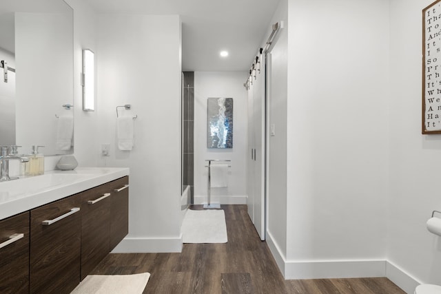 130 Durango Rd Unit 104, Destin, FL 32541 - bathroom featuring vanity, a shower with shower door, wood finished floors, baseboards, and recessed lighting
