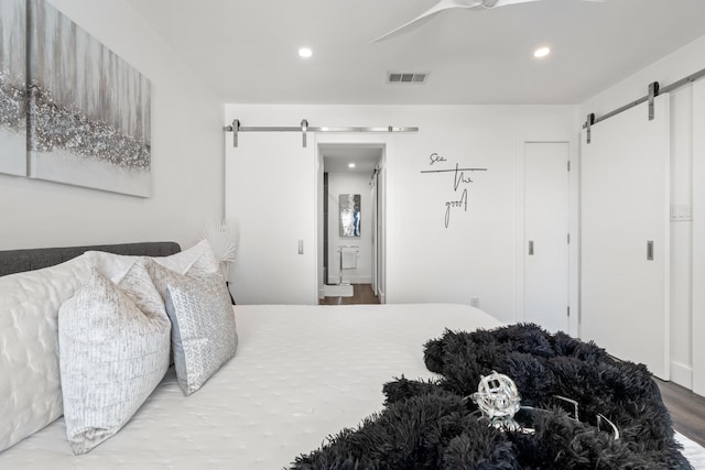130 Durango Rd Unit 104, Destin, FL 32541 - bedroom with a barn door, wood finished floors, recessed lighting, and ensuite bath