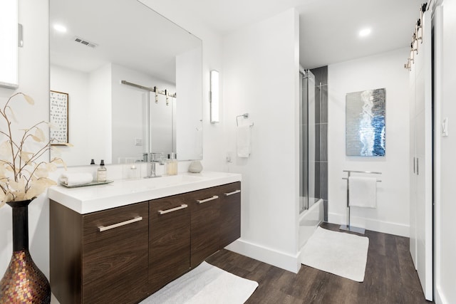 130 Durango Rd Unit 104, Destin, FL 32541 - full bathroom featuring vanity, wood finished floors, baseboards, bath / shower combo with glass door, and recessed lighting