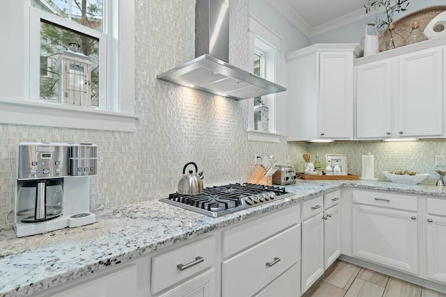 58 E Milestone Dr Unit B, Inlet Beach, FL 32461 - kitchen featuring wall chimney range hood, stainless steel gas stovetop, decorative backsplash, ornamental molding, and white cabinets