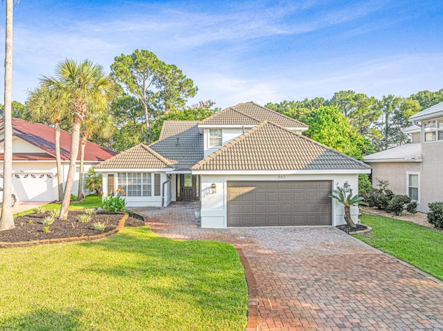 865 Indigo Loop, Destin, FL 32550 - view of front facade featuring a tiled roof, a garage, a front yard, driveway, and stucco siding