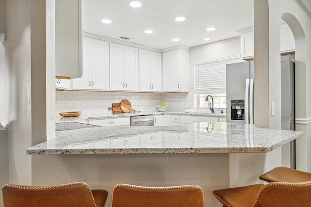 865 Indigo Loop, Destin, FL 32550 - kitchen with a sink, backsplash, white cabinetry, a kitchen breakfast bar, and light stone countertops