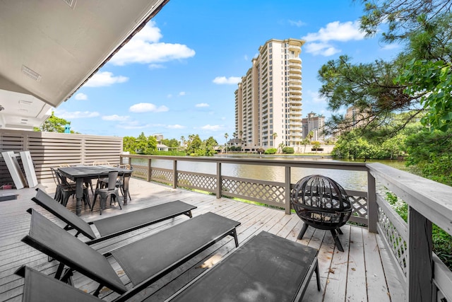 5209 Beachwalk Dr, Miramar Beach, FL 32550 - wooden deck with outdoor dining area and a water view
