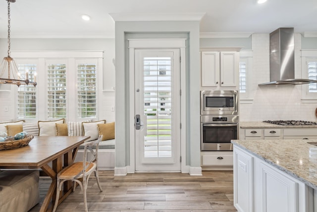 25 E Pine Lands Loop Unit B, Inlet Beach, FL 32461 - kitchen with appliances with stainless steel finishes, wall chimney exhaust hood, breakfast area, ornamental molding, and a chandelier