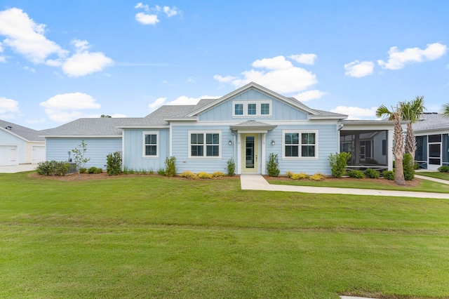 8454 Dreams Float Ct, Panama City Beach, FL 32413 - view of front of property featuring a sunroom, a front yard, board and batten siding, and roof with shingles