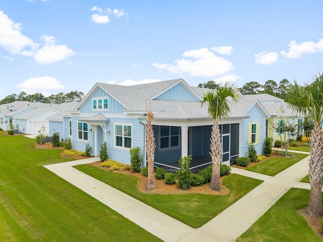 8454 Dreams Float Ct, Panama City Beach, FL 32413 - view of front of home featuring board and batten siding, roof with shingles, a front lawn, and a sunroom