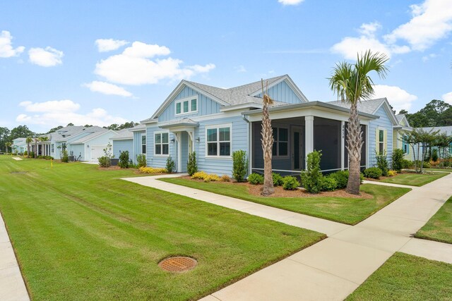 8454 Dreams Float Ct, Panama City Beach, FL 32413 - view of front of home with board and batten siding, a front lawn, and a sunroom
