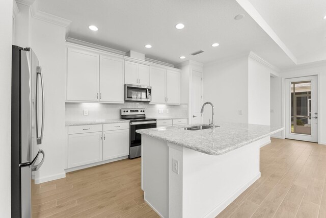 8454 Dreams Float Ct, Panama City Beach, FL 32413 - kitchen with stainless steel appliances, a sink, light wood-style floors, white cabinets, and recessed lighting