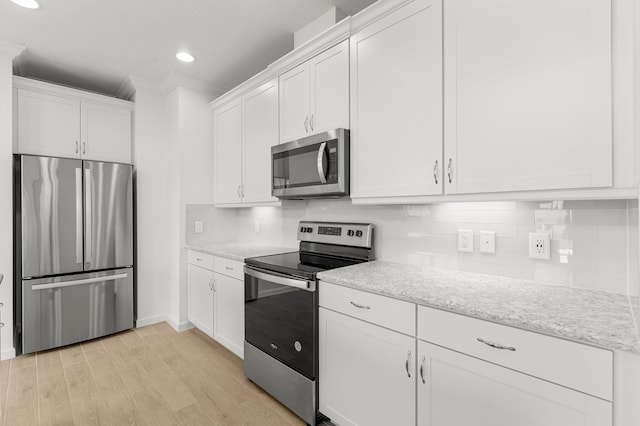 8454 Dreams Float Ct, Panama City Beach, FL 32413 - kitchen with stainless steel appliances, crown molding, white cabinets, light wood-style flooring, and decorative backsplash