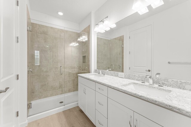 8454 Dreams Float Ct, Panama City Beach, FL 32413 - bathroom featuring a stall shower, double vanity, recessed lighting, and wood finished floors