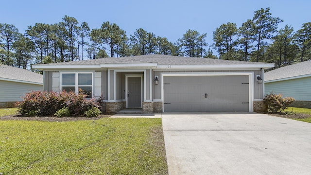 720 Riverwalk Cir, Freeport, FL 32439 - view of front of house featuring a garage, driveway, a front lawn, and stone siding