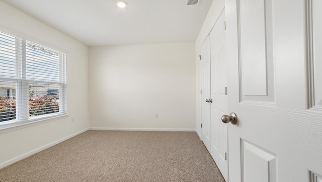 720 Riverwalk Cir, Freeport, FL 32439 - unfurnished bedroom with light carpet, baseboards, and a closet