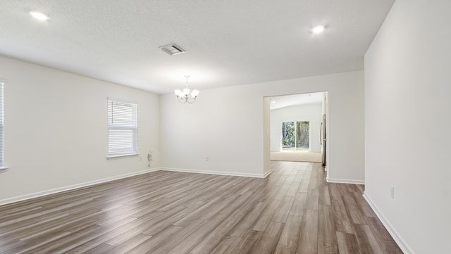 720 Riverwalk Cir, Freeport, FL 32439 - empty room featuring a chandelier, dark wood finished floors, and baseboards