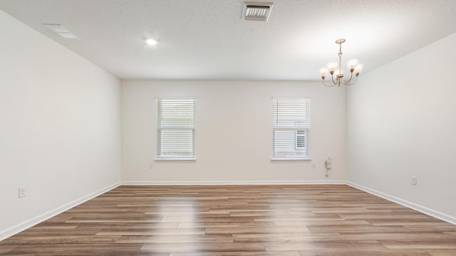 720 Riverwalk Cir, Freeport, FL 32439 - unfurnished room featuring light wood finished floors, a chandelier, and baseboards