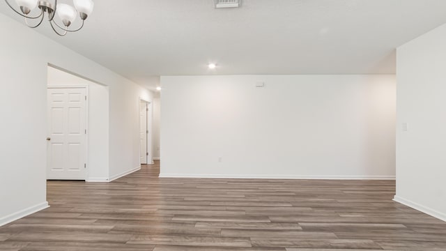 720 Riverwalk Cir, Freeport, FL 32439 - unfurnished room with wood finished floors, baseboards, a chandelier, and recessed lighting