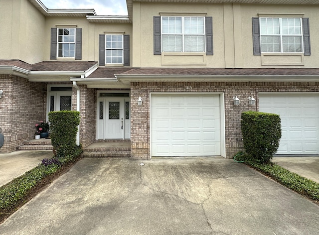 413 Nathey Ave Unit 10, Niceville, FL 32578 - view of front of house featuring driveway, an attached garage, brick siding, and stucco siding