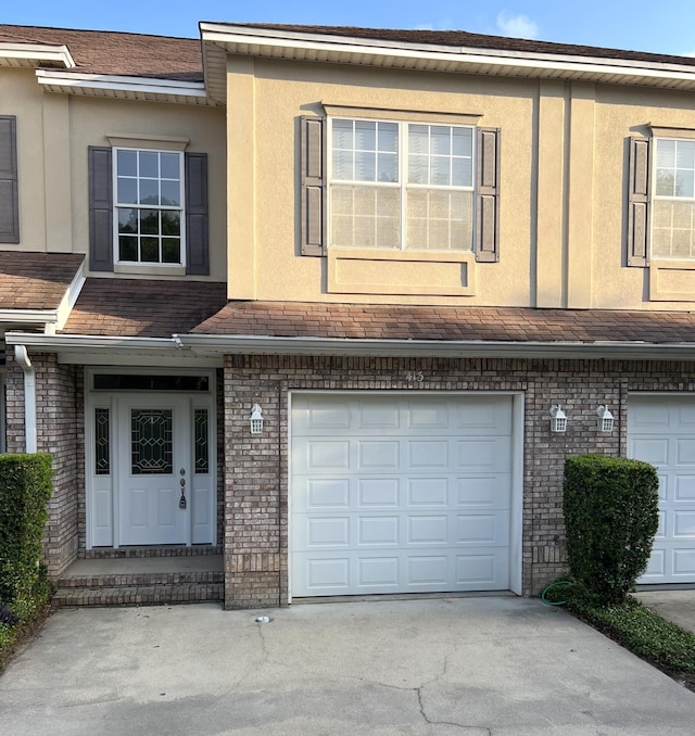 413 Nathey Ave Unit 10, Niceville, FL 32578 - multi unit property featuring a garage, brick siding, concrete driveway, and stucco siding