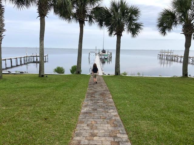 6735 Tidewater Dr, Navarre, FL 32566 - dock area featuring a water view and a lawn