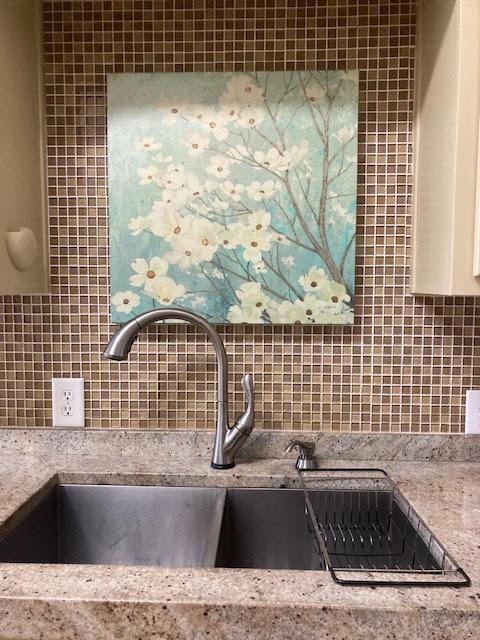 6735 Tidewater Dr, Navarre, FL 32566 - kitchen view of backsplash, a sink, and white cabinetry