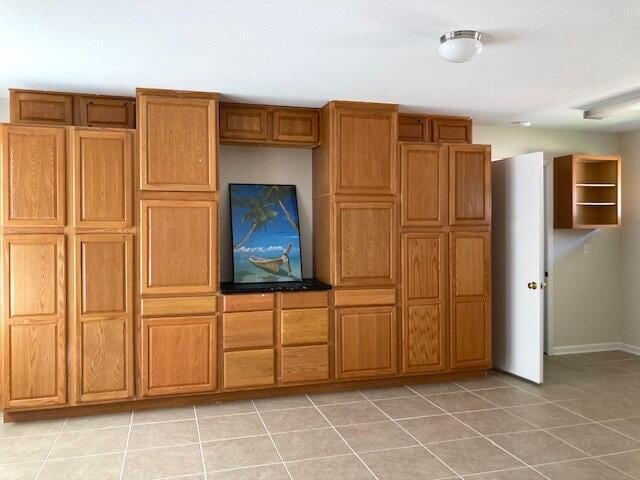 6735 Tidewater Dr, Navarre, FL 32566 - kitchen featuring light tile patterned floors, brown cabinetry, and baseboards