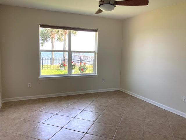 6735 Tidewater Dr, Navarre, FL 32566 - spare room featuring ceiling fan, tile patterned flooring, and baseboards