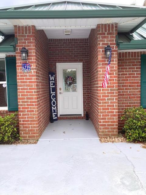6735 Tidewater Dr, Navarre, FL 32566 - doorway to property with brick siding