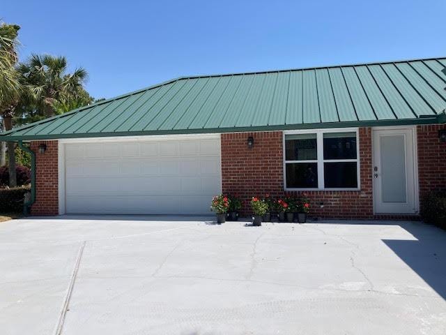 6735 Tidewater Dr, Navarre, FL 32566 - view of side of property featuring brick siding, concrete driveway, and a garage