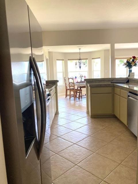 6735 Tidewater Dr, Navarre, FL 32566 - kitchen featuring stainless steel appliances, dark countertops, a chandelier, and light tile patterned floors