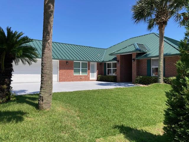 6735 Tidewater Dr, Navarre, FL 32566 - ranch-style house featuring a standing seam roof, a front yard, metal roof, and brick siding