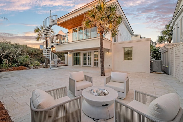 40 Jasmine Cir, Santa Rosa Beach, FL 32459 - patio terrace at dusk featuring stairs, cooling unit, a patio, an outdoor living space with a fire pit, and french doors
