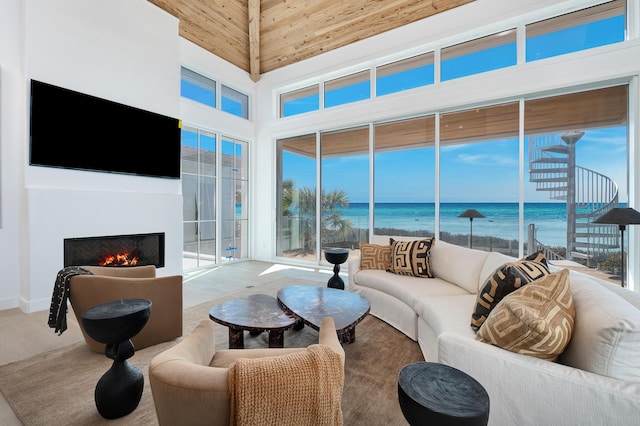40 Jasmine Cir, Santa Rosa Beach, FL 32459 - living room with a towering ceiling, a water view, a lit fireplace, and plenty of natural light