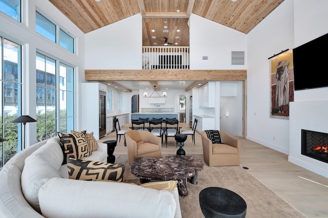 40 Jasmine Cir, Santa Rosa Beach, FL 32459 - living room featuring wood ceiling, high vaulted ceiling, a lit fireplace, light wood-type flooring, and baseboards