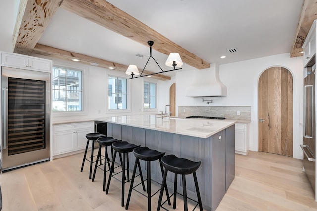 40 Jasmine Cir, Santa Rosa Beach, FL 32459 - kitchen with beverage cooler, arched walkways, extractor fan, light wood-type flooring, and beamed ceiling