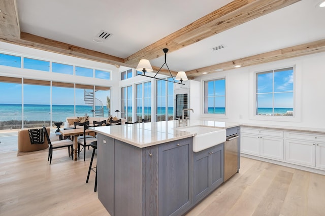 40 Jasmine Cir, Santa Rosa Beach, FL 32459 - kitchen featuring a sink, gray cabinets, beamed ceiling, light wood-style floors, and an island with sink