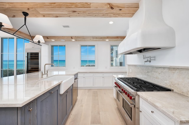 40 Jasmine Cir, Santa Rosa Beach, FL 32459 - kitchen with range with two ovens, island range hood, a sink, wine cooler, and white cabinets
